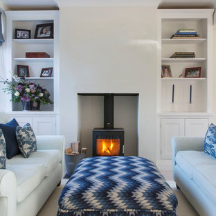 Foto di un piccolo soggiorno stile marinaro con pareti beige, moquette e stufa a legna
