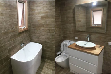 Photo of a small modern 3/4 bathroom in Melbourne with white cabinets, a freestanding tub, a corner shower, brown tile, porcelain tile, brown walls, porcelain floors, wood benchtops, brown floor, a hinged shower door, brown benchtops, a niche, a single vanity and a built-in vanity.