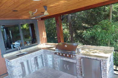 Outdoor kitchen deck - large traditional backyard second story outdoor kitchen deck idea in Seattle with a roof extension