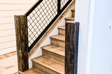 Imagen de escalera de estilo de casa de campo con barandilla de metal