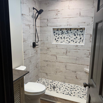 Rustic Farmhouse Bathroom Remodel with Wood-Look Tile and Pebble Shower Floor
