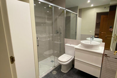 Modelo de cuarto de baño principal y único moderno pequeño con ducha empotrada, encimera de madera, ducha con puerta corredera y encimeras blancas