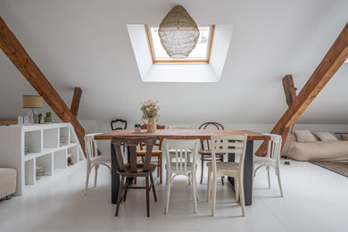 Cette photo montre une très grande salle à manger ouverte sur le salon nature avec un mur blanc, parquet peint, un sol blanc, poutres apparentes et éclairage.
