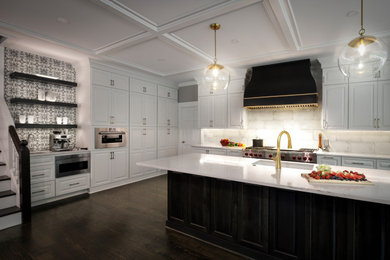 Example of a mid-sized transitional l-shaped dark wood floor, black floor and coffered ceiling kitchen pantry design in Atlanta with an undermount sink, raised-panel cabinets, white cabinets, quartzite countertops, beige backsplash, ceramic backsplash, stainless steel appliances, an island and white countertops