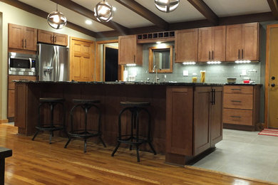 Mid-sized transitional galley ceramic tile eat-in kitchen photo in Columbus with an undermount sink, shaker cabinets, medium tone wood cabinets, quartz countertops, gray backsplash, glass tile backsplash, stainless steel appliances and an island