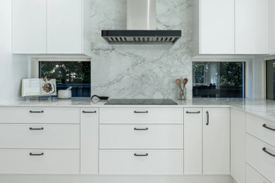 Design ideas for an expansive modern u-shaped eat-in kitchen in Sydney with a double-bowl sink, shaker cabinets, white cabinets, grey splashback, black appliances, with island, beige floor and grey benchtop.
