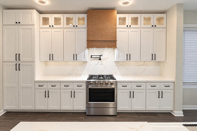 Inspiration for a large contemporary porcelain tile and brown floor kitchen remodel in Houston with a farmhouse sink, shaker cabinets, white cabinets, quartz countertops, white backsplash, quartz backsplash, stainless steel appliances, an island and white countertops
