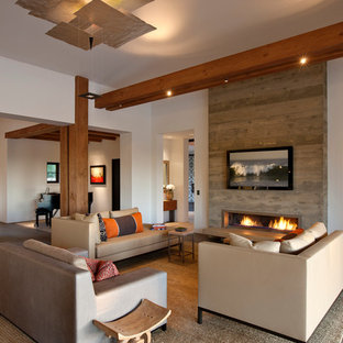 Imagen de salón para visitas abierto, mediterráneo, con paredes blancas, suelo de madera oscura, chimenea lineal, marco de chimenea de metal y televisor colgado en la pared