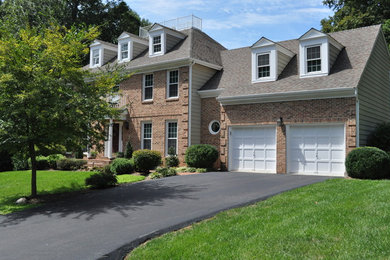 Large and brown traditional two floor brick house exterior in DC Metro with a pitched roof.