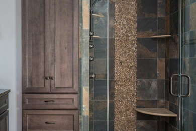 Example of a mid-sized mountain style master multicolored tile and porcelain tile porcelain tile corner shower design in Philadelphia with recessed-panel cabinets, medium tone wood cabinets, a one-piece toilet, gray walls, an undermount sink and granite countertops