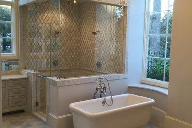 Mid-sized minimalist master marble tile marble floor bathroom photo in Houston with beige walls, marble countertops and a hinged shower door