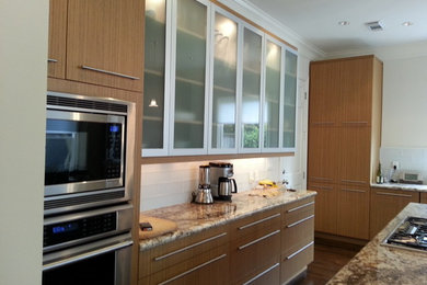 Inspiration for a mid-sized contemporary u-shaped medium tone wood floor and brown floor eat-in kitchen remodel in Houston with an undermount sink, flat-panel cabinets, light wood cabinets, granite countertops, white backsplash, glass tile backsplash, stainless steel appliances and an island