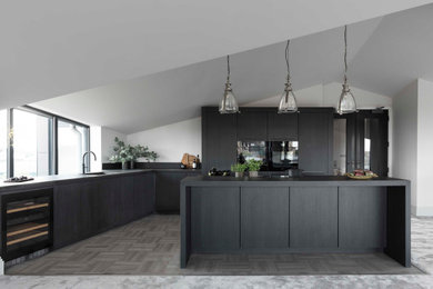 Design ideas for a medium sized contemporary l-shaped open plan kitchen in Other with a built-in sink, flat-panel cabinets, dark wood cabinets, engineered stone countertops, black appliances, an island, grey floors and black worktops.