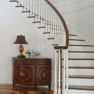 Inspiration for a large timeless wooden curved staircase remodel in New York with painted risers