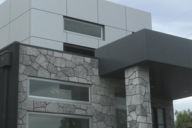 Inspiration for an industrial grey exterior in Geelong with stone veneer, a flat roof and a metal roof.