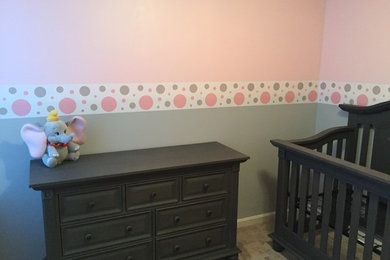 Ejemplo de habitación de bebé niña moderna de tamaño medio con paredes rosas