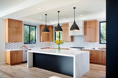 Inspiration for a large modern l-shaped open plan kitchen in San Francisco with a farmhouse sink, flat-panel cabinets, medium wood cabinets, quartz benchtops, white splashback, ceramic splashback, stainless steel appliances, light hardwood floors, with island, beige floor and white benchtop.