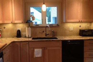 Example of a small minimalist porcelain tile enclosed kitchen design in New York with an undermount sink, light wood cabinets, granite countertops, beige backsplash, stone tile backsplash and black appliances
