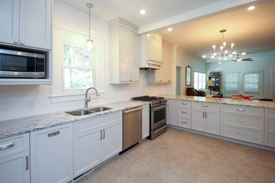Example of a transitional l-shaped porcelain tile open concept kitchen design in Raleigh with an undermount sink, shaker cabinets, gray cabinets, granite countertops, white backsplash, subway tile backsplash and stainless steel appliances