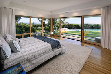 Midcentury bedroom in Santa Barbara with white walls, medium hardwood floors and brown floor.