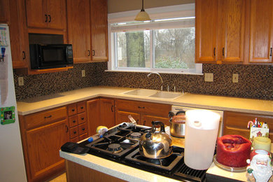 Transitional kitchen photo in St Louis with a double-bowl sink, medium tone wood cabinets, multicolored backsplash, mosaic tile backsplash and white appliances