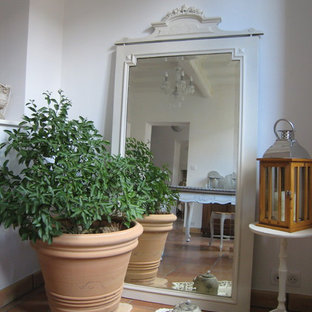 Idee per un soggiorno country di medie dimensioni con pareti bianche, pavimento in terracotta, camino classico e cornice del camino in legno