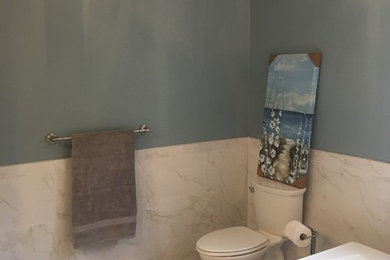 Example of a large trendy master white tile and porcelain tile porcelain tile and gray floor bathroom design in Richmond with raised-panel cabinets, white cabinets, a one-piece toilet, blue walls, an undermount sink, granite countertops and a hinged shower door
