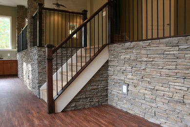 Basement - transitional walk-out dark wood floor basement idea in DC Metro with green walls, a standard fireplace and a stone fireplace
