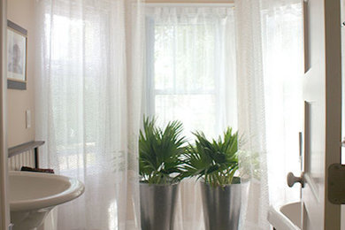 Bathroom - mid-sized traditional gray tile and glass tile porcelain tile bathroom idea in New York with a pedestal sink, white cabinets, a two-piece toilet and beige walls
