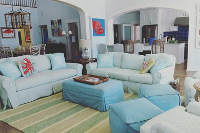 Example of a mid-sized beach style open concept medium tone wood floor and brown floor family room design in Tampa with white walls
