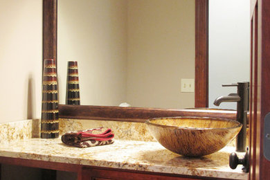 Inspiration for a mid-sized craftsman bathroom remodel in Minneapolis with raised-panel cabinets, dark wood cabinets, a two-piece toilet, beige walls, a vessel sink and granite countertops