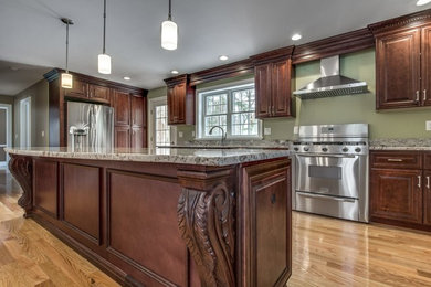 Inspiration for a mid-sized timeless light wood floor and yellow floor eat-in kitchen remodel in Raleigh with an undermount sink, raised-panel cabinets, medium tone wood cabinets, granite countertops, stainless steel appliances, an island and beige countertops