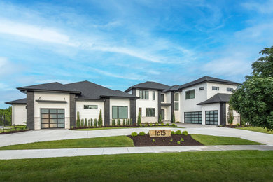 Huge trendy three-story mixed siding house exterior photo in Omaha with a hip roof, a shingle roof and a black roof
