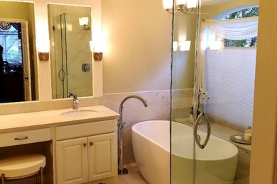 Bathroom - large traditional master white tile and porcelain tile porcelain tile and white floor bathroom idea in Austin with raised-panel cabinets, white cabinets, a two-piece toilet, gray walls, an undermount sink, quartzite countertops and a hinged shower door
