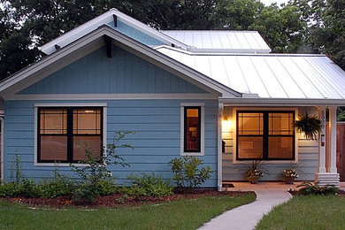 Photo of a mid-sized traditional two-storey blue exterior with wood siding and a gable roof.