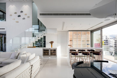 Large contemporary home bar in Other with glass-front cabinets, white cabinets, marble worktops, white worktops, concrete flooring and beige floors.