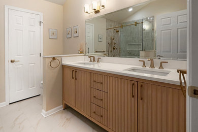 Large transitional master brown tile and porcelain tile porcelain tile, white floor and double-sink sliding shower door photo in Philadelphia with furniture-like cabinets, light wood cabinets, a one-piece toilet, beige walls, an undermount sink, quartz countertops, pink countertops, a niche and a built-in vanity