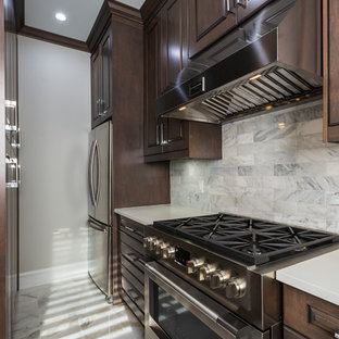 Bild på ett litet vintage vit vitt kök, med en undermonterad diskho, luckor med upphöjd panel, bruna skåp, bänkskiva i kvarts, grått stänkskydd, stänkskydd i marmor, rostfria vitvaror, marmorgolv och beiget golv