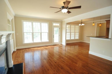 Living room - transitional medium tone wood floor living room idea in Calgary with beige walls, a standard fireplace and a wood fireplace surround