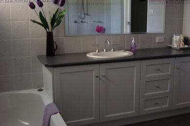 Contemporary bathroom in Melbourne with white cabinets.