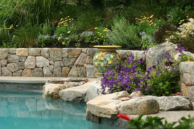 Example of a mid-sized mountain style backyard stamped concrete and custom-shaped lap hot tub design in Boston