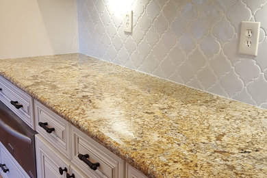 Example of a huge classic l-shaped medium tone wood floor and brown floor eat-in kitchen design in Austin with a farmhouse sink, white cabinets, granite countertops, white backsplash, ceramic backsplash, stainless steel appliances and an island