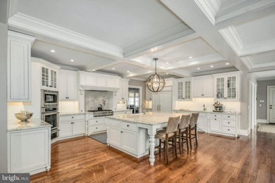 Design ideas for an expansive kitchen in Philadelphia with a farmhouse sink, beaded inset cabinets, white cabinets, timber splashback, medium hardwood floors, with island and coffered.