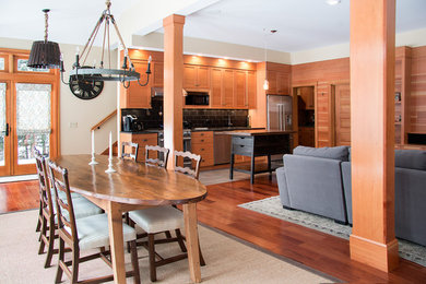 Inspiration for a huge timeless l-shaped medium tone wood floor eat-in kitchen remodel in Burlington with an undermount sink, shaker cabinets, medium tone wood cabinets, granite countertops, black backsplash, stainless steel appliances and an island