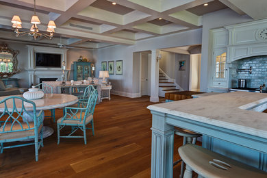 Eat-in kitchen - large transitional l-shaped medium tone wood floor and brown floor eat-in kitchen idea in Miami with a farmhouse sink, raised-panel cabinets, blue cabinets, quartzite countertops, white backsplash, subway tile backsplash, stainless steel appliances and an island