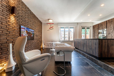 Imagen de salón abierto extra grande con televisor colgado en la pared, suelo gris y ladrillo