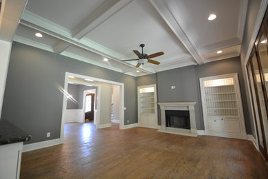 Inspiration for a huge rustic open concept medium tone wood floor living room remodel in Birmingham with gray walls, a standard fireplace, a stone fireplace and a wall-mounted tv