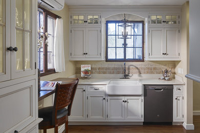 Enclosed kitchen - mid-sized traditional l-shaped dark wood floor and brown floor enclosed kitchen idea in Philadelphia with a farmhouse sink, recessed-panel cabinets, white cabinets, quartzite countertops, beige backsplash, ceramic backsplash, stainless steel appliances and no island