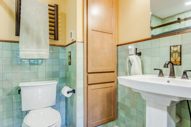 Bathroom - small craftsman green tile and ceramic tile white floor, single-sink and wainscoting bathroom idea in St Louis with a one-piece toilet, yellow walls, a pedestal sink and a niche