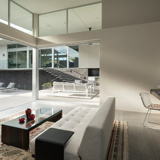 Design ideas for a large modern study in Los Angeles with porcelain flooring, a built-in desk, beige walls, no fireplace and grey floors.